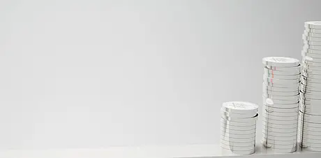 Mehrere weiße Münzstapel in ansteigender Höhe vor hellem Hintergrund – Symbol für finanzielles Wachstum, Ertrag und wirtschaftlichen Erfolg.